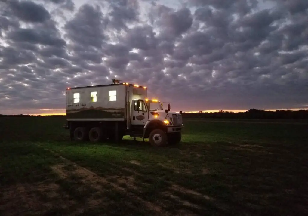 A truck is parked in the middle of a field.